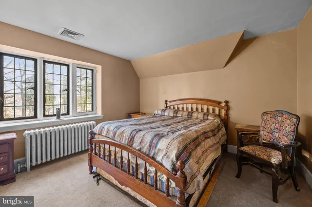 a bedroom with a bed chair and window
