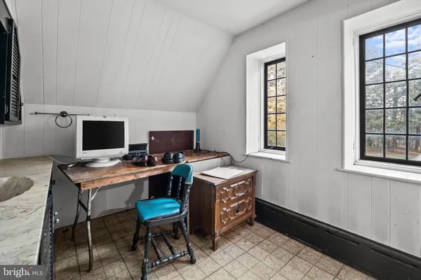 a view of a workspace with furniture and a window