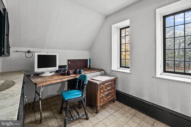 a view of a workspace with furniture and a window