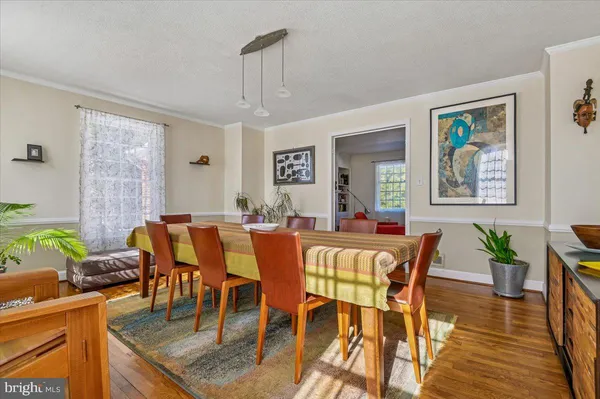 a dining room with furniture a window and wooden floor