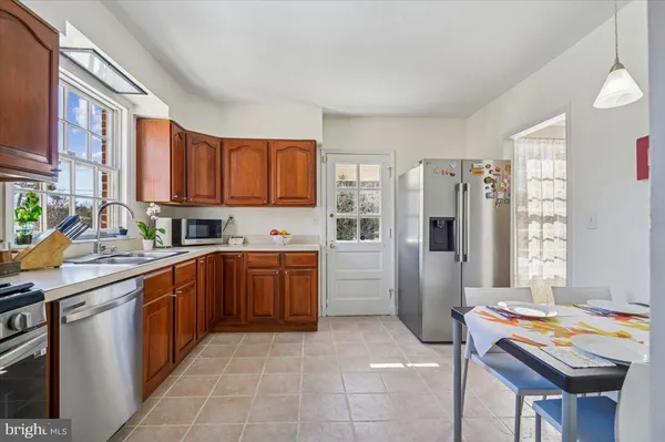 a kitchen with stainless steel appliances granite countertop a stove a sink dishwasher and a refrigerator
