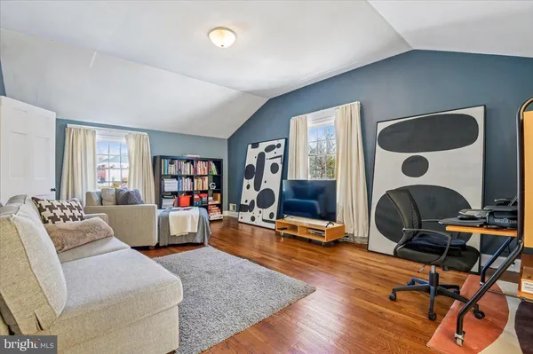 a spacious bedroom with a bed and wooden floor