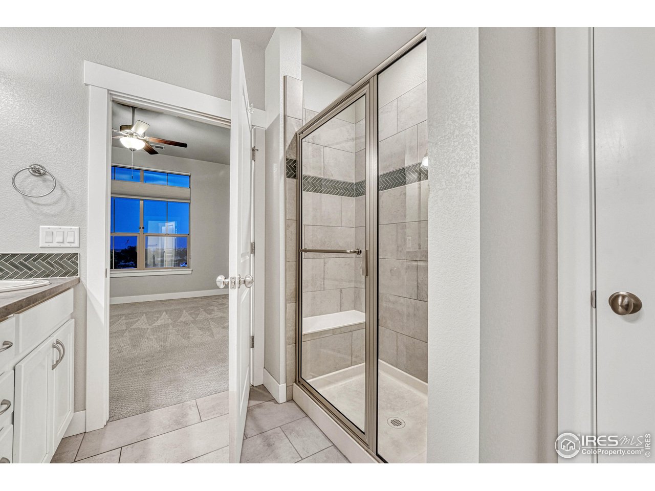 6582 Crystal Downs Drive, Unit 207 Windsor, CO 80550 - Photo 25 of 40 Shower with bench in this bright and airy primary bathroom