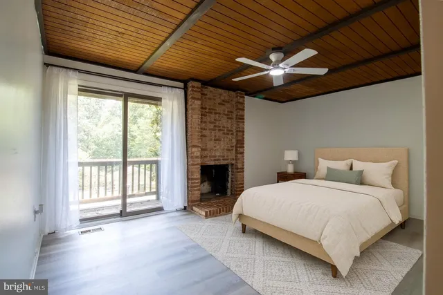 a bedroom with a large bed wooden floor and a ceiling fan