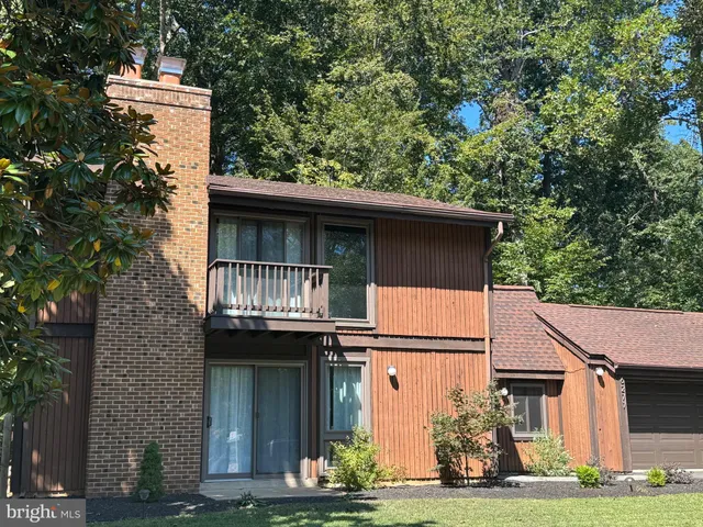 a view of a white house with large windows and a small yard