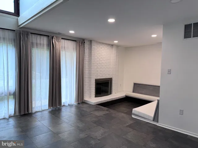 an empty room with wooden floor and fireplace
