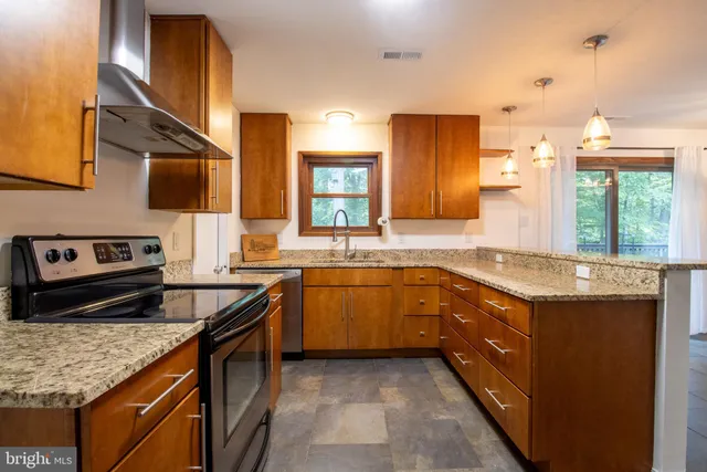 a kitchen with stainless steel appliances granite countertop a sink stove and cabinets