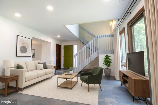 a living room with furniture a rug and a flat screen tv