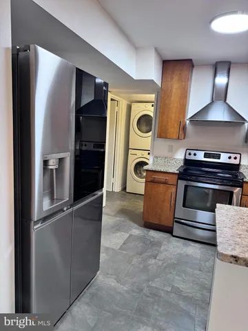 a kitchen with stainless steel appliances granite countertop a refrigerator and a stove