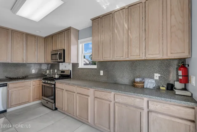 a kitchen with stainless steel appliances granite countertop a sink a stove and cabinets