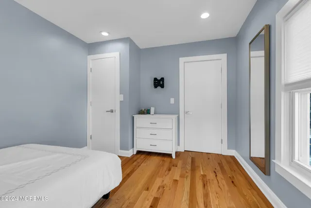 a view of a bedroom with wooden floor and cabinet