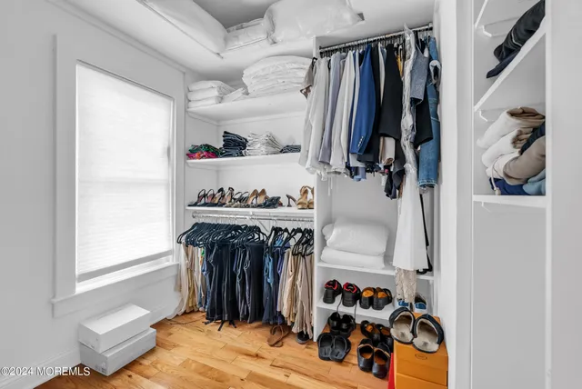 a view of walk in closet with clothes and shoes