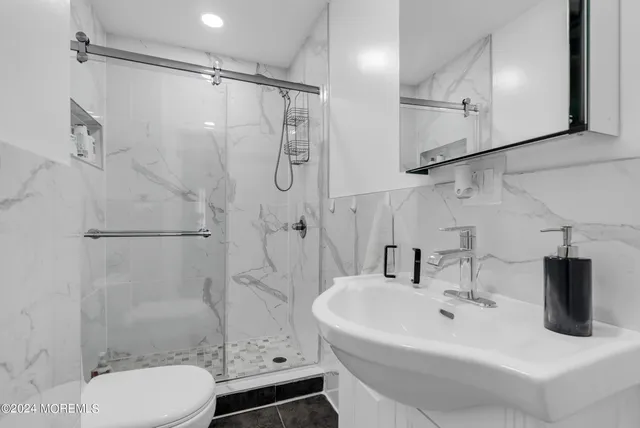 a bathroom with a sink toilet and shower