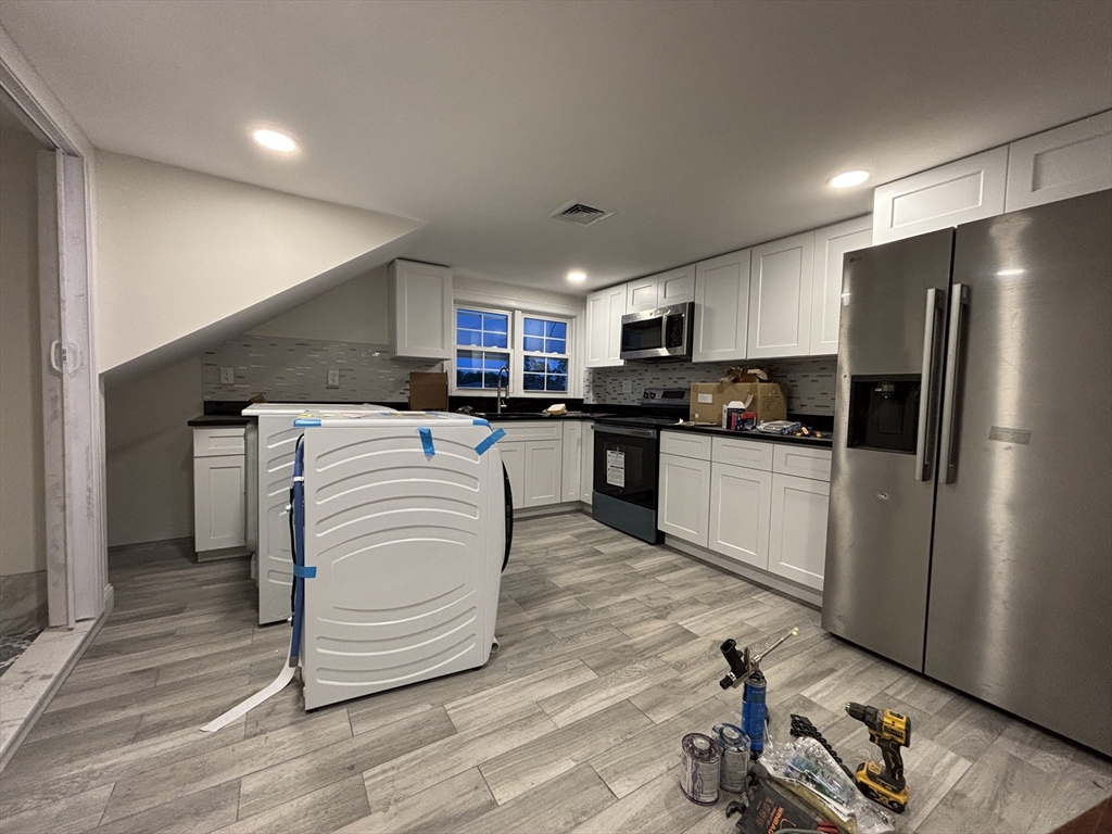 4 Appleton Street, Unit D Quincy, MA 02171 - Photo 2 of 12 a kitchen with kitchen island a white cabinets and refrigerator