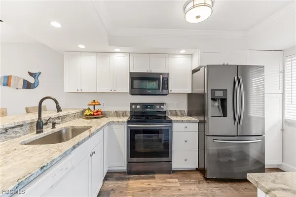 a kitchen with stainless steel appliances granite countertop a refrigerator stove and sink