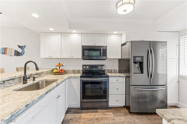a kitchen with stainless steel appliances granite countertop a refrigerator stove and sink