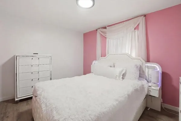 a large bed sitting in a bedroom next to a window