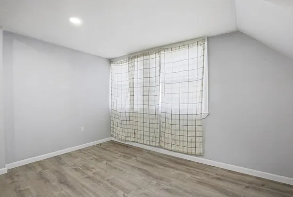 a view of an empty room with wooden floor