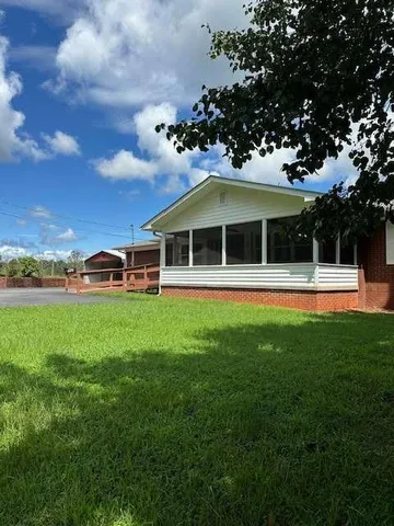 a front view of a house with a garden and trees