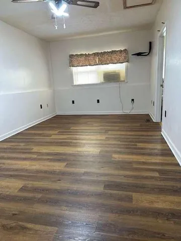a view of a room with wooden floor and fan