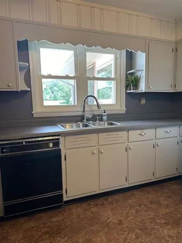 a kitchen with granite countertop white cabinets white appliances and a sink