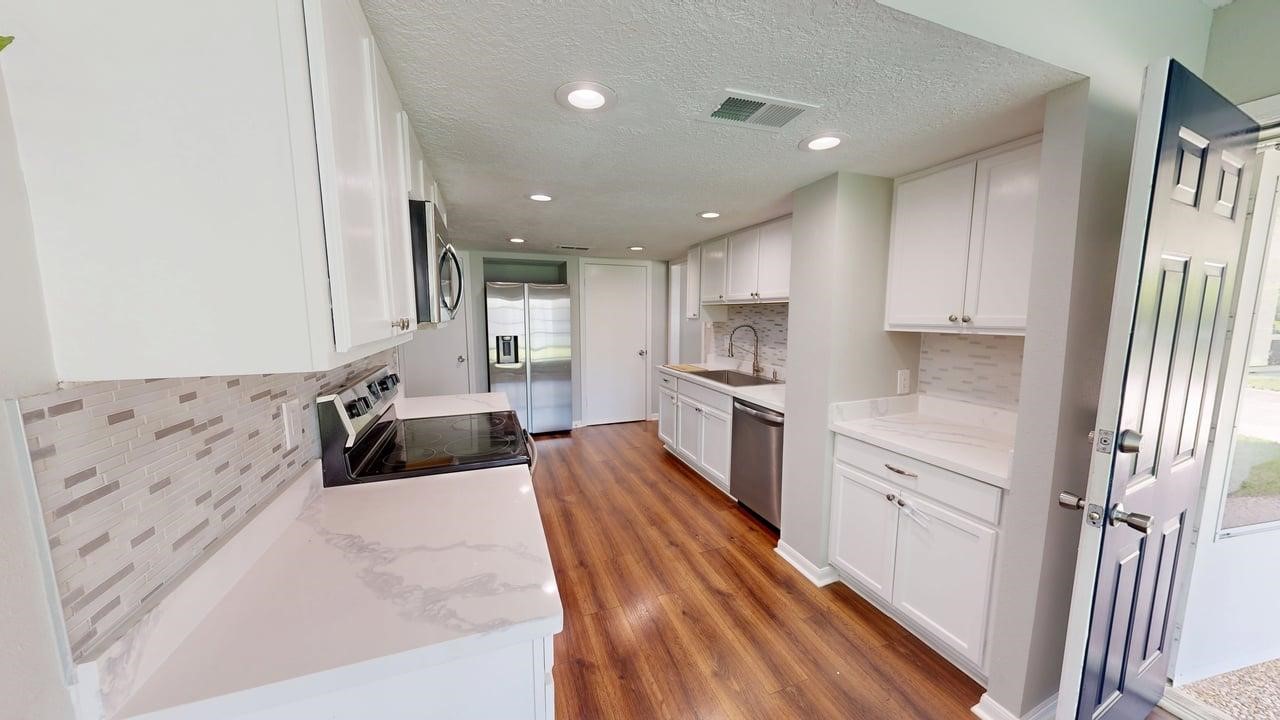 619 Cotter Drive Spring, TX 77373 - Photo 23 of 50 a large kitchen with stainless steel appliances granite countertop a lot of counter space and wooden floors