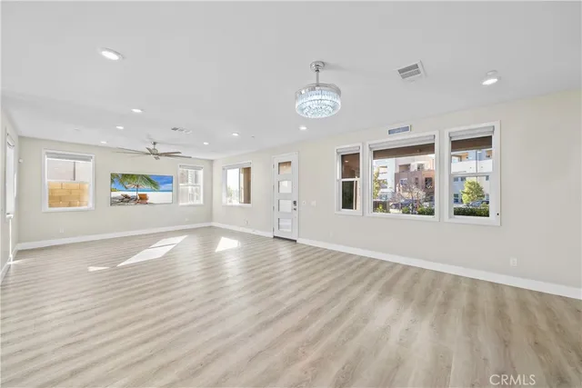 a large white kitchen with wooden floors and stainless steel appliances