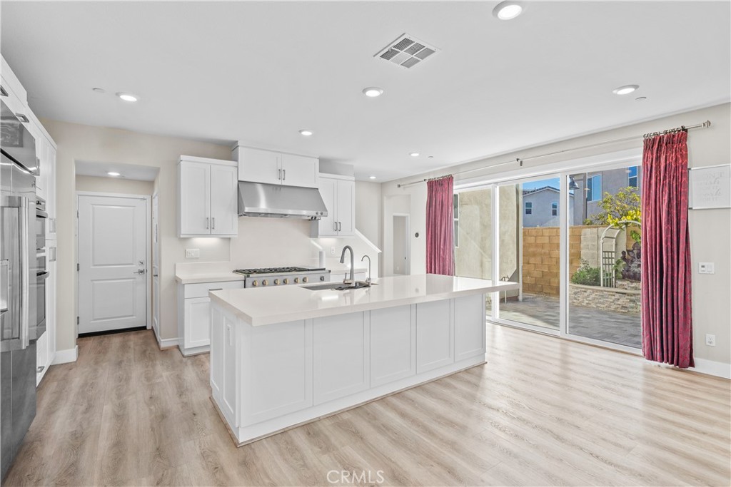 124 Zawn Irvine, CA 92618 - Photo 12 of 56 a large white kitchen with wooden floors and stainless steel appliances