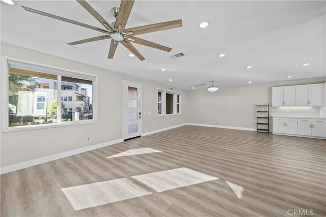 an empty room with wooden floor and window