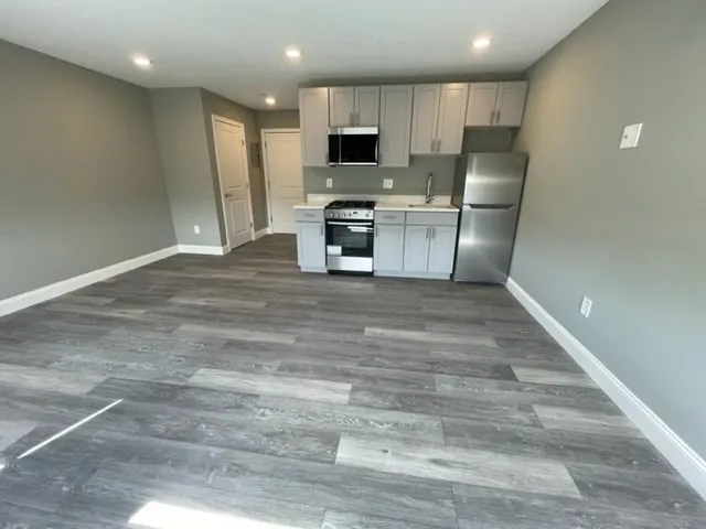 a kitchen with granite countertop a refrigerator and a stove