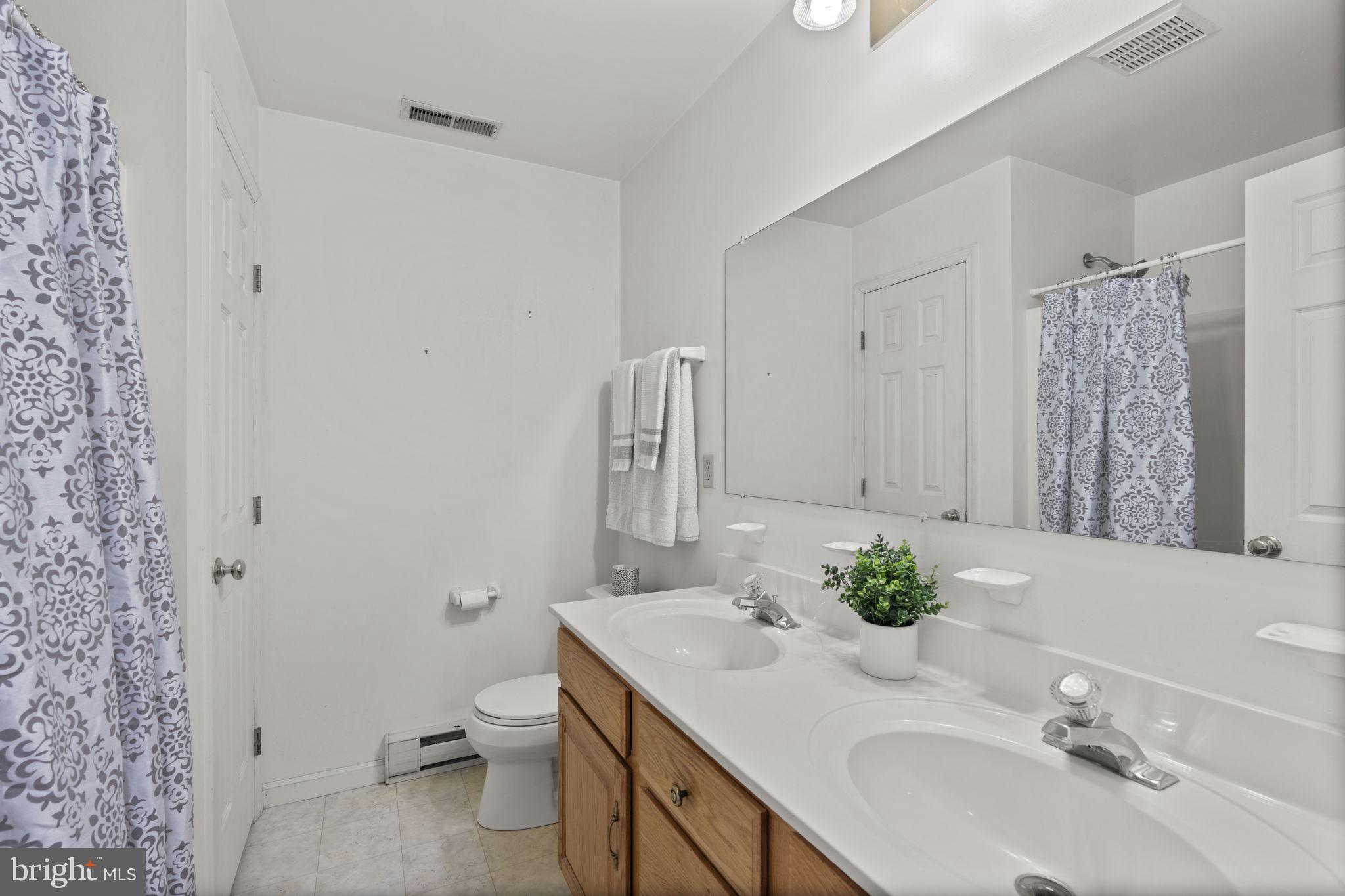 5715 Emory Road Upperco, MD 21155 - Photo 21 of 43 a bathroom with a granite countertop sink a toilet and a mirror