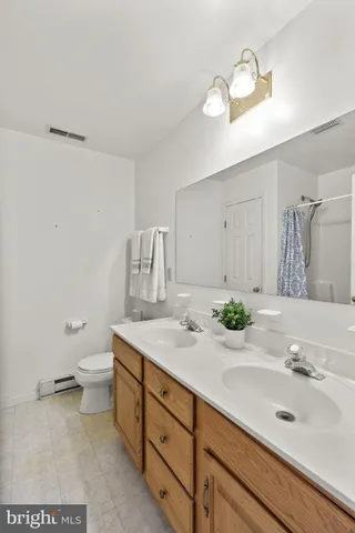 a bathroom with a granite countertop sink a toilet and a mirror