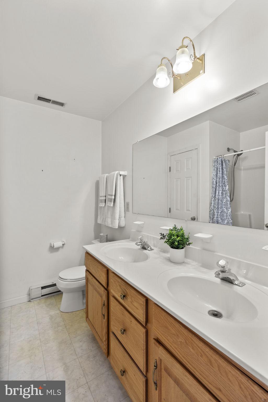 5715 Emory Road Upperco, MD 21155 - Photo 23 of 43 a bathroom with a granite countertop sink a toilet and a mirror