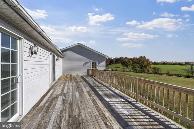 a view of a balcony with wooden floor and fence