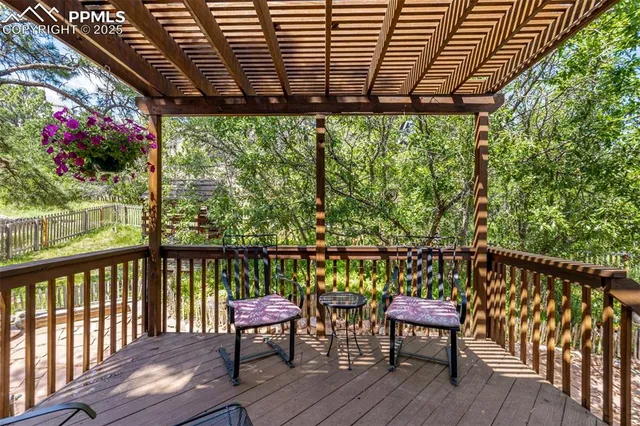 a balcony with wooden floor table and chairs