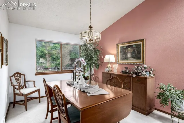 a dining room with furniture a chandelier and window
