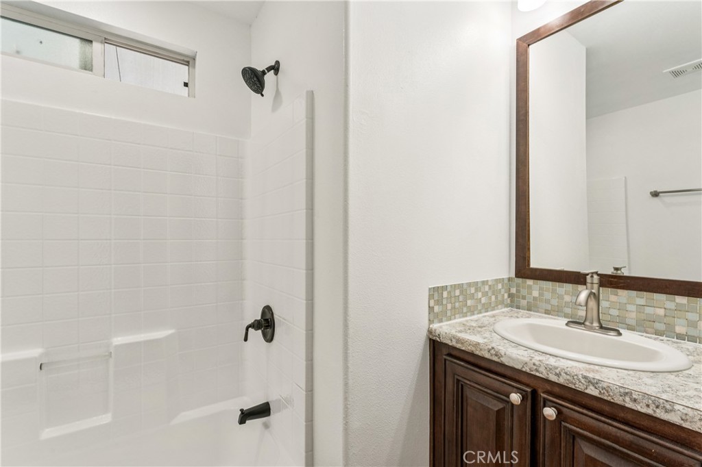 10550 Dunlap Crossing Road, Unit 141 Whittier, CA 90606 - Photo 17 of 38 a bathroom with a granite countertop sink a mirror and shower