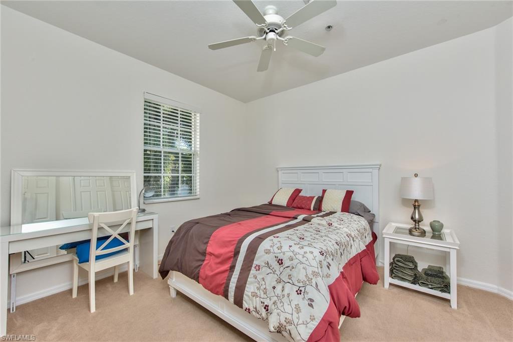 12859 Carrington Circle, Unit 3202 Naples, FL 34105 - Photo 11 of 28 a bedroom with a bed and a table