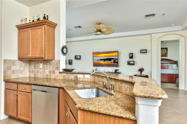 a kitchen with granite countertop a sink and a wooden cabinets