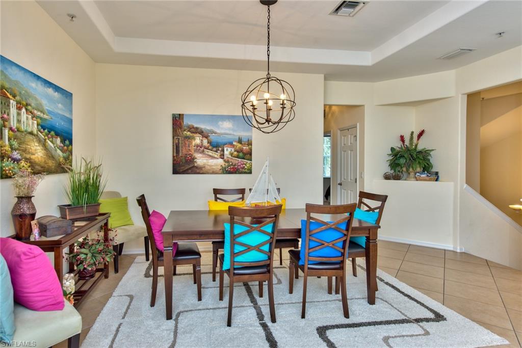12859 Carrington Circle, Unit 3202 Naples, FL 34105 - Photo 7 of 28 a view of a dining room with furniture and chandelier