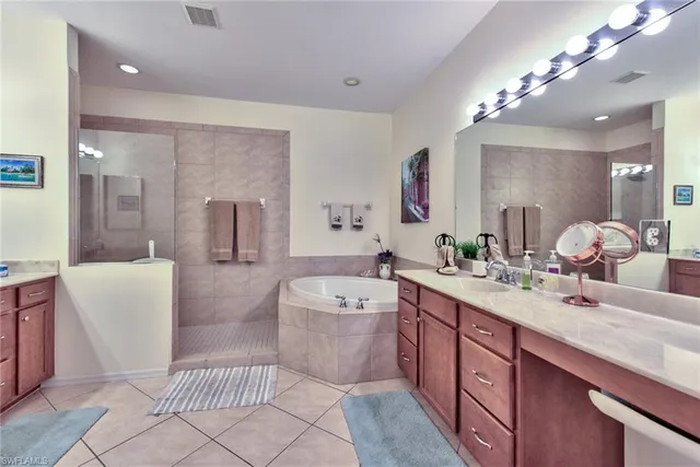 a spacious bathroom with a tub sink and mirror