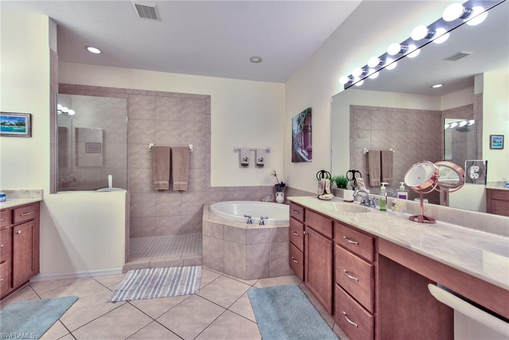 12859 Carrington Circle, Unit 3202 Naples, FL 34105 - Photo 9 of 28 a spacious bathroom with a tub sink and mirror