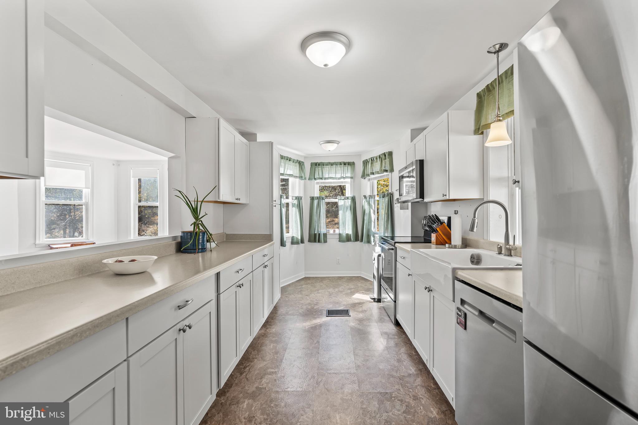 13608 Maryland Avenue Blue Ridge Summit, PA 17214 - Photo 16 of 80 a large white kitchen with stainless steel appliances