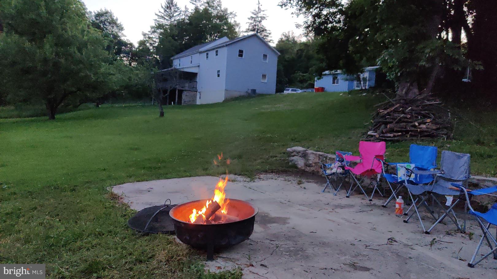 13608 Maryland Avenue Blue Ridge Summit, PA 17214 - Photo 56 of 80 a view of a backyard with table and chairs and potted plants and large trees