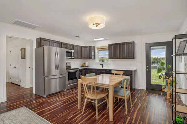 a kitchen with stainless steel appliances a stove a table and chairs