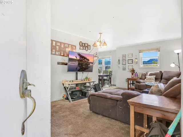 a living room with furniture a flat screen tv and a window