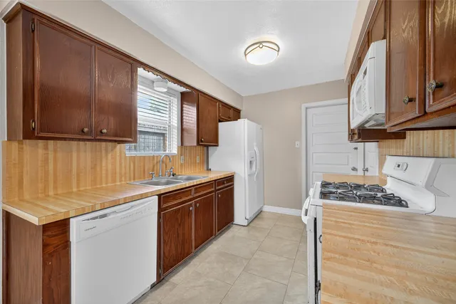 a kitchen with stainless steel appliances kitchen island granite countertop a sink stove and refrigerator