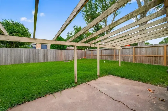 a view of a backyard with plants and wooden fence