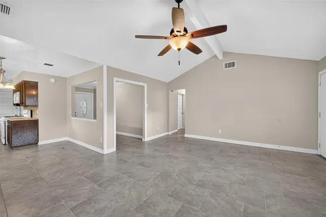 an empty room with fan and windows