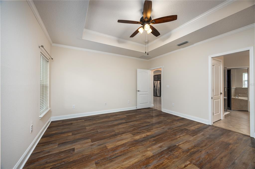 8216 Northwest 54th Street Gainesville, FL 32653 - Photo 36 of 58 an empty room with wooden floor ceiling fan and windows